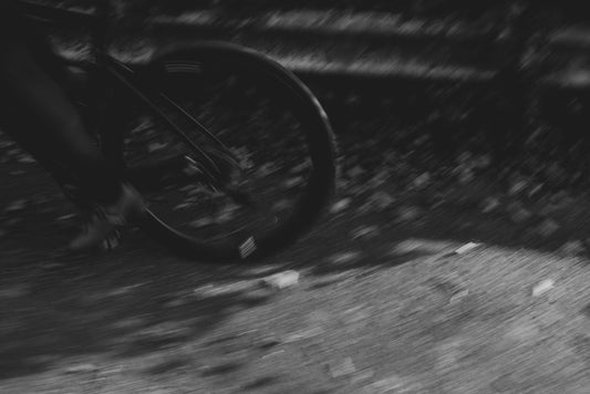 Blurry motion of a cyclist riding a bike, highlighting the dynamic movement. The image captures the essence of athleticism and outdoor activity. Experience the freedom of movement with RVE Compression gear, designed to support your active lifestyle.