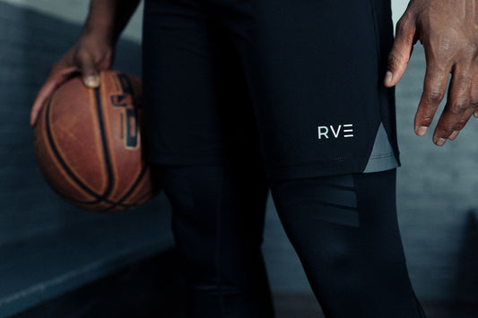 wearing RVE Compression gear, holding a basketball. The apparel features the RVE logo, representing cutting-edge compression technology for enhanced performance and comfort. Ideal for athletes seeking advanced support during physical activity.